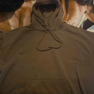 Brun hoodie från Amisu - Säljer en brun hoodie från Amisu i storlek XL. Den är perfekt för höst och vinter med sin mysiga och varma känsla. Hoodien har en klassisk design med en stor ficka framtill och justerbar dragsko i huvan.