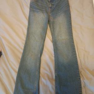 Blå jeans från Monki - Säljer ett par snygga blå jeans från Monki i waist 26. De är lågmidjade och flared. Aldrig använda, säljer för att de är för stora