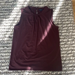 Vinröd ärmlös topp från Stockh LM - Säljer en stilren vinröd ärmlös topp från Stockh LM i storlek S. Toppen har en enkel design med rund halsringning och är perfekt för både vardag och fest. Materialet känns mjukt och bekvämt mot huden.