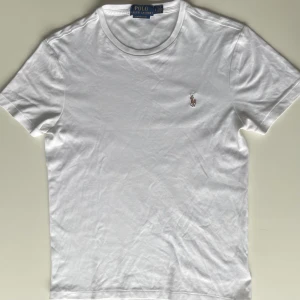 Ralph Lauren T-shirt  - Fräsch vit Ralph Lauren T-shirt, 9/10 skick om inte 10/10. Passar egentligen för både killar och tjejer. Jag är 173,5 cm och väger runt 60 kg, och den sitter perfekt. Nypris ca 1000 kr, ett riktigt kap! DM:a snabbt om du är intresserad! 👕😎