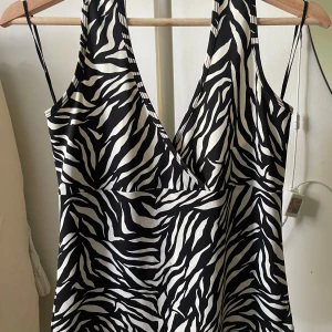 Zebramönstdad topp - Jättefin halterneck i zebramönster, superfint skick men har dock en liten fläck som knappt syns därför säljer jag för 120 kr. I storlek L❤️🥰