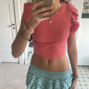 Rosa ribbad topp från Zara - Säljer en superfin rosa ribbad topp från Zara. Den har volangdetaljer på ärmarna som ger en söt touch. Toppen är croppad och passar perfekt till sommaren. Den är i storlek S.💕