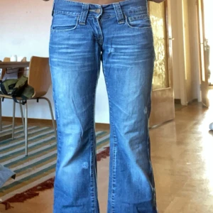 Blå jeans från Fornarina - Säljer ett par snygga blå jeans från Fornarina. De har en låg midja och benen är i bootcut. Jeansen har en jättefin blå wash med lite slitningar. Vid dragkedjan saknas tyvärr den större platta delen💗🙃