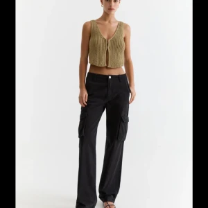 Svarta cargopants - Säljer ett par svarta cargopants med breda ben och praktiska fickor på sidorna. Byxorna har en knapp och dragkedja framtill. Perfekta för en avslappnad och stilren look. Köpt från Pull&Bear för 399kr säljer för endast 115kr