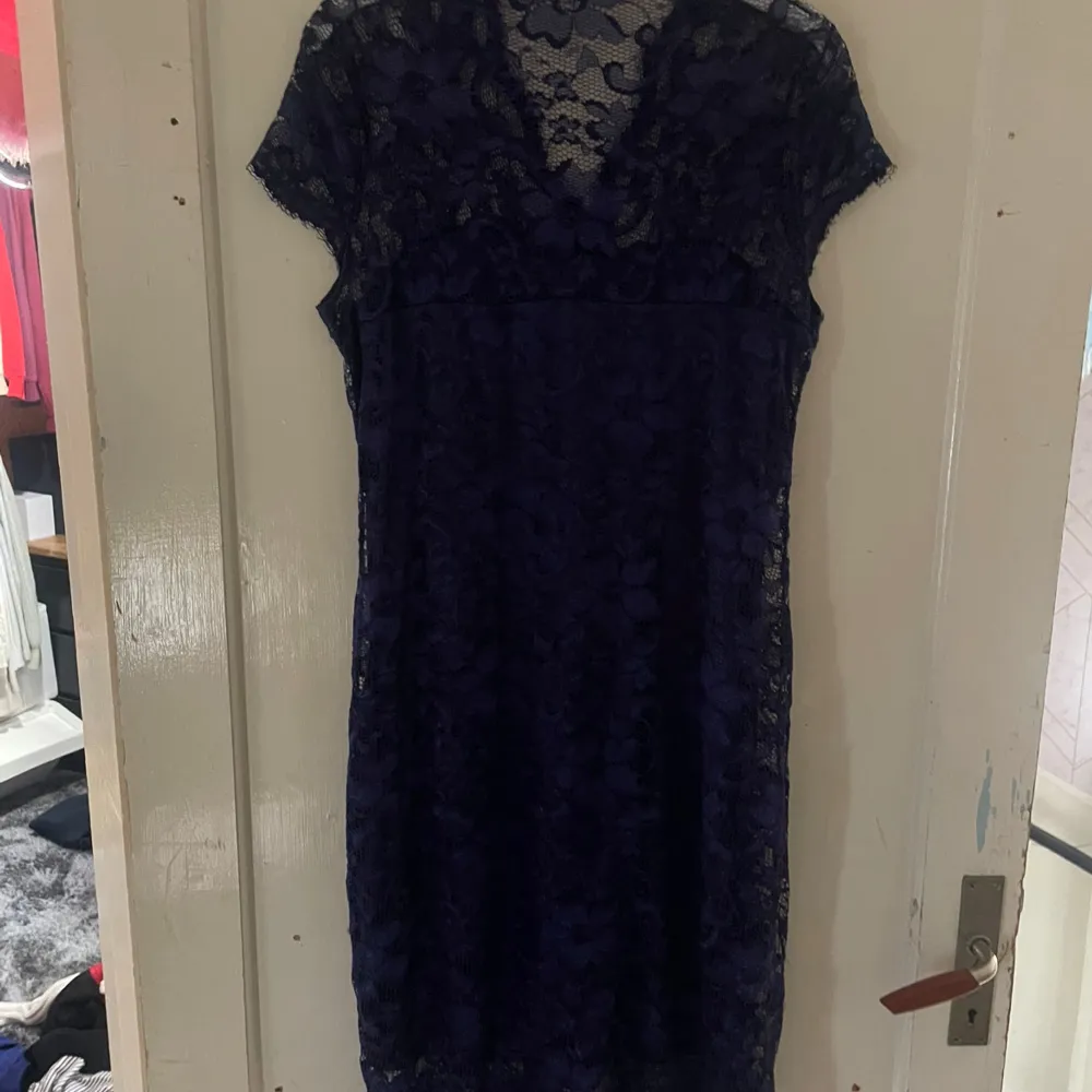 Säljer en elegant mörkblå spetsklänning i storlek XXL. Klänningen har en vacker spetsdesign och korta ärmar. Perfekt för festliga tillfällen eller en utekväll. Den är i nyskick och redo att bäras av någon som vill känna sig extra fin!. Mekot.
