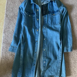 Jeans klänning  - Den är helt ny och prislappen är fortfarande kvar. Säljer den för att den är för stor för mig. Köpt för 350kr men säljer den för 200kr. Passar jättebra för höst/sommar💕