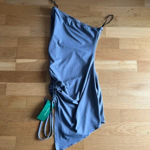 Blå klänning med justerbara axelband - Ny med prislapp! snygg blå klänning, drapering på sidan. Perfekt för sommardagar eller en avslappnad festkväll. Materialet känns mjukt och skönt mot huden.🫶🏽