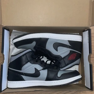 Jordan 1 Mid Shadow Red - Jordan 1 mid shadow red som är köpta från restocks för 2400kr och är 100% autentiska. De har endast blivit använda en gång och är i extremt bra skick och ser helt nya ut. Skorna är i storlek 45 och original Jordan låda medföljer.
