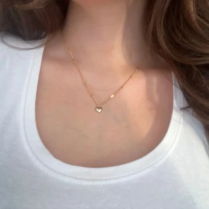 halsband med hjärthänge - Säljer ett elegant halsband med ett litet hjärthänge. Perfekt för både vardag och festliga tillfällen. Halsbandet är enkelt men stilrent och passar till alla outfits. Ett måste för den som älskar subtila smycken! 💖