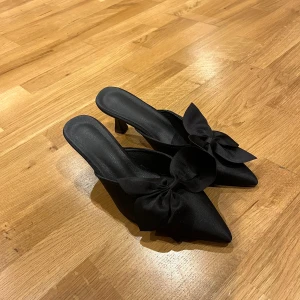 Svarta klackskor med rosett - Snygga svarta klackskor med en elegant rosett på framsidan. Perfekta för festliga tillfällen med en spetsig tå och stilren design. Klackarna ger en chic look och passar bra till både klänning och byxor. endast testade❤️‍🔥