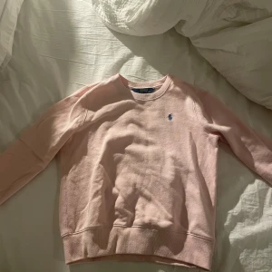 Rosa tröja från Polo Ralph Lauren - Säljer en superfin tröja från Polo Ralph Lauren. Rosa med blått märke i ca st 140-146 skulle jag säga. Tröjan är i bra skick och har inga tecken på andväning❣️
