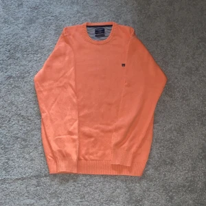 Orange tröja från Hackett London - Säljer en snygg orange tröja från Hackett London i storlek XL. Den är gjord av finaste italienska bomull och har en klassisk design med ribbade muddar. Perfekt för både vardag och lite finare tillfällen. Passar bra till höst och vår!