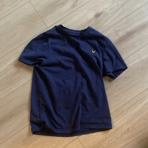 Mörkblå t-shirt från Lyle & Scott - Säljer en snygg mörkblå t-shirt från Lyle & Scott i storlek XS. Inte lika skrynklig som den ser ut på bilden.