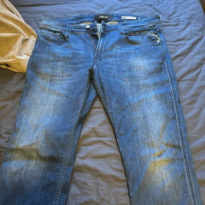 Blåa anbass från Replay - Säljer ett par snygga blå jeans från Replay i modellen Anbass. De har en klassisk femficksdesign och en bekväm passform. Perfekta för både vardag och fest! 🕺34w 32L