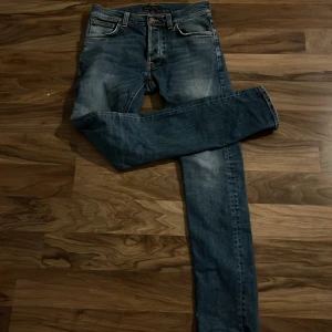 Blå jeans från Nudie tilted tor - Säljer ett par feta blå nudie jeans🤙Dom är sjukt goa och snygga perfekt till skolan och fest🍾 storlek W29/L32 (priset ej hugget i sten)