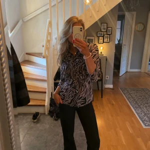 Zebramönstrad blus - Säljer en snygg zebramönstrad blus med långa ärmar. Perfekt för både vardag och fest! Blusen har en bekväm passform och är gjord i ett mjukt material. Den är stilren och lätt att matcha med olika outfits. Passar perfekt för höst och vår.