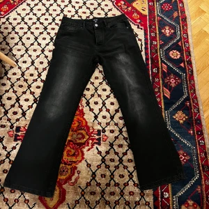 Svarta bootcut jeans - Säljer ett par svarta jeansbyxor i bra skick. De har en  bootcut passform och är perfekta för både vardag och fest. Byxorna har en knapp och dragkedja framtill samt fickor både fram och bak. Passar till alla säsonger och är ett måste i garderoben!