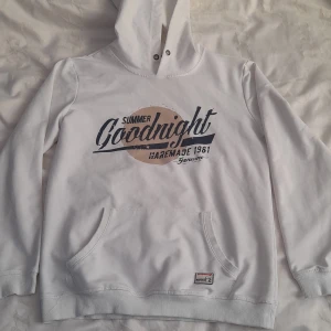 Vit hoodie från Suporlar - Säljer en vit hoodie från Suporlar med trycket 'Summer Goodnight' i blått och beige på framsidan. Den har en stor ficka fram och en bekväm huva. Perfekt för en avslappnad stil eller kyliga sommarkvällar. Märket 'Marines Work Gear' finns på nederkanten. Hör av dig vid intresse!