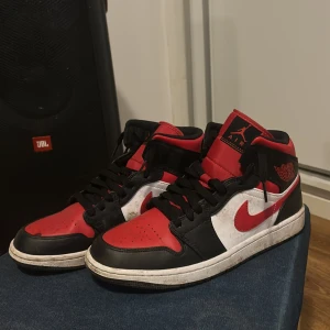 Nike Air Jordans i rött, svart och vitt - Säljer ett par klassiska Nike Air Jordans i rött, svart och vitt. Skorna har en snygg design med snörning och är i bra skick. Perfekta för både vardag och fest! De har en cool retrostil som aldrig går ur tiden. Skorna är även lite smutsiga men jag tvättar dom innan jag säljer dem. 
