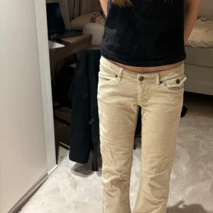 Beigea low waist bootcut manchesterbyxor - Säljer ett par snygga beige manchesterbyxor i bra skick. De är lågmidjade och har en bootcut passform. 