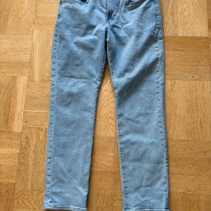 Blå jeans från H&M - Säljer ett par klassiska blå jeans från H&M i regular fit. De är i bra skick och perfekta för vardagsbruk. Jeansen har en normal passform och är tillverkade i ett slitstarkt denimtyg. Perfekta för både vår och höst!