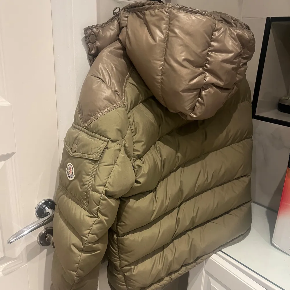 Säljer nu min unika olivgröna pufferjacka från Moncler. Retail pris: 12 800kr. Jackan är perfekt för kalla dagar med sin tjocka vaddering och har en praktisk huva. Den har en dragkedja framtill och Monclers logga på ärmen. Perfekt för vintern och hösten! Priset kan diskuteras vid snabbaffär! . Jackor.