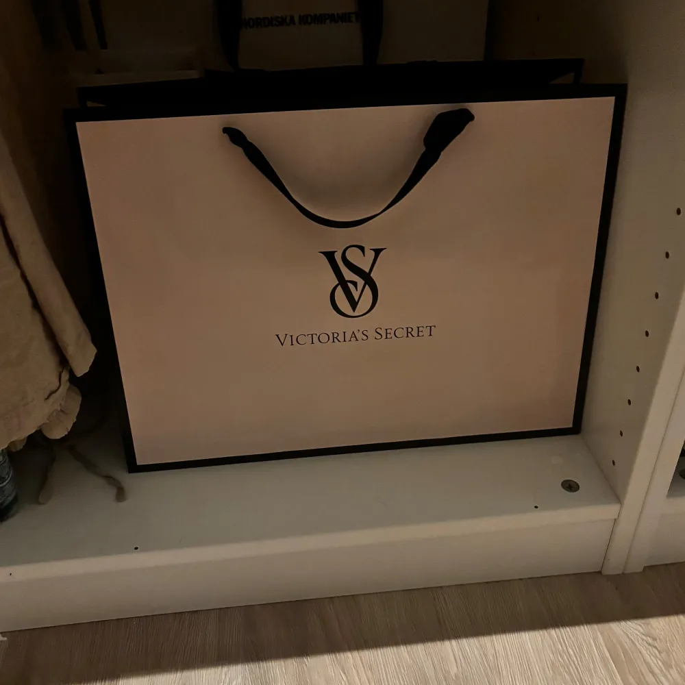 Snygg shoppingväska från Victoria's Secret i rosa med svarta detaljer och logga. Perfekt för en shoppingrunda eller som presentpåse. Den har svarta handtag och är i mycket bra skick.. Väskor.