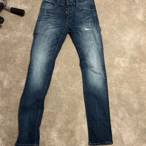 Blå jeans från Sam Glenn - Säljer ett par snygga blå jeans från Sam Glenn i storlek 29/34. De har en cool slitningseffekt och en klassisk femficksdesign. Perfekta för en avslappnad stil eller en utekväll. Passar bra till både sneakers och kängor!