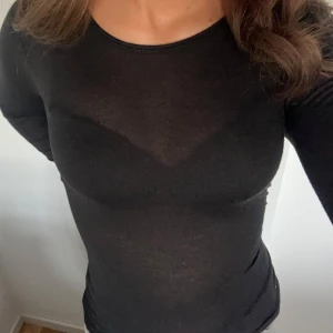 Svart långärmad topp från MNG - Säljer en stilren svart långärmad topp från MNG. Perfekt för både vardag och fest. Den är i ett mjukt och stretchigt material som sitter skönt på kroppen. Passar bra till jeans eller kjol för en snygg look. Likar intimissimi tröjan