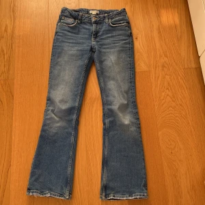 Blå bootcut jeans från Gina Tricot - Säljer ett par snygga blå bootcut jeans från Gina Tricot. De har en klassisk femficksdesign och en dragkedja med knapp framtill. Perfekta för både vardag och fest! 🕺
