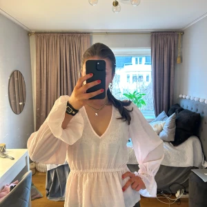 Ljusrosa blus från Gina Tricot  - Säljer en stilren ljusrosa blus med v-ringning och långa ärmar. Blusen har en lätt volangdetalj vid ärmsluten och midjan. Perfekt för att klä upp eller ner beroende på tillfälle💗