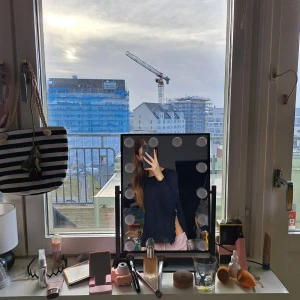 Marinblå tröja med volangdetaljer - Säljer en svart stickad tröja med fina volangdetaljer längs sidorna. Tröjan har en enkel design och är perfekt för en stilren look. Passar bra till både jeans och kjol.