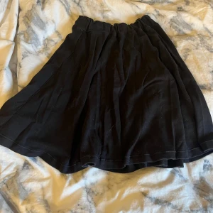 Svart kjol - Medel lång kjol som går till knäna ungefär. Resårband i midjan så kan passa alla från XS till L. Är sydd själv så finns inget märke.