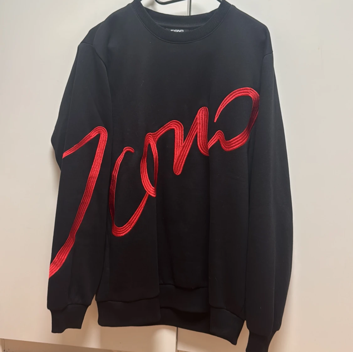 Svart sweatshirt med röd text