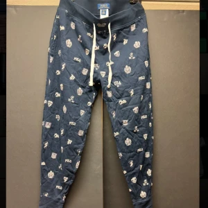 Mörkblå pyjamasbyxor från Polo Ralph Lauren - Säljer dessa riktigt bekväma pyjamasbyxor med väldigt fina detaljer från Polo Ralph Lauren. Har använts helt okej många gånger men är o bra skicka och inga defekter. Nypris cirka 899KR. Dessa är väldigt feta! Vid några funderingar skriv🫡