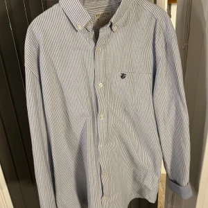 Randig skjorta från Selected Homme - Snygg blå- och vitrandig skjorta från Selected Homme. Skjortan har långa ärmar och en klassisk krage.