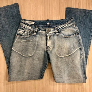 Lågmidjade bootcut jeans - Lågmidjade bootcut jeans med en avslappnad känsla De är stretchiga och väldigt mjuka i tyget! De har en liten fläck på ena knät (bild 3), men det är inget man tänker på Midjemått: 36cm rakt över  Innerbenslängd: 70cm