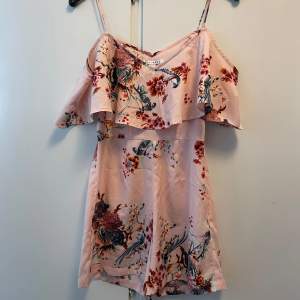 Rosa, blommig playsuit från Nelly. Storlek 34. Mycket fint skick, använd ett fåtal gånger.