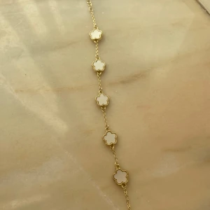 Armband - Säljer detta fina armband med blommor på!! Nästan nyskick💘💘 guld med vita detaljer