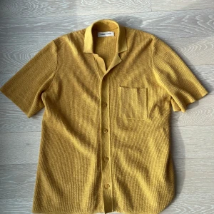 Gul stickad skjorta från Samsøe Samsøe - Stickad tröja från Samsøe Samsøe i honungsgult. Storlek M     Linne & bomulls mix                   Nypris ~ 1400 kr