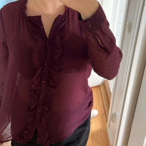 Vin röd blus - Säljer en jättefint och söt topp, i tunt material som är vinröd/ lite lila. Jätte fin och har volanger där fram. Är genomskinlig så tycker det är fint att ha den med en röd bh under. ❤️