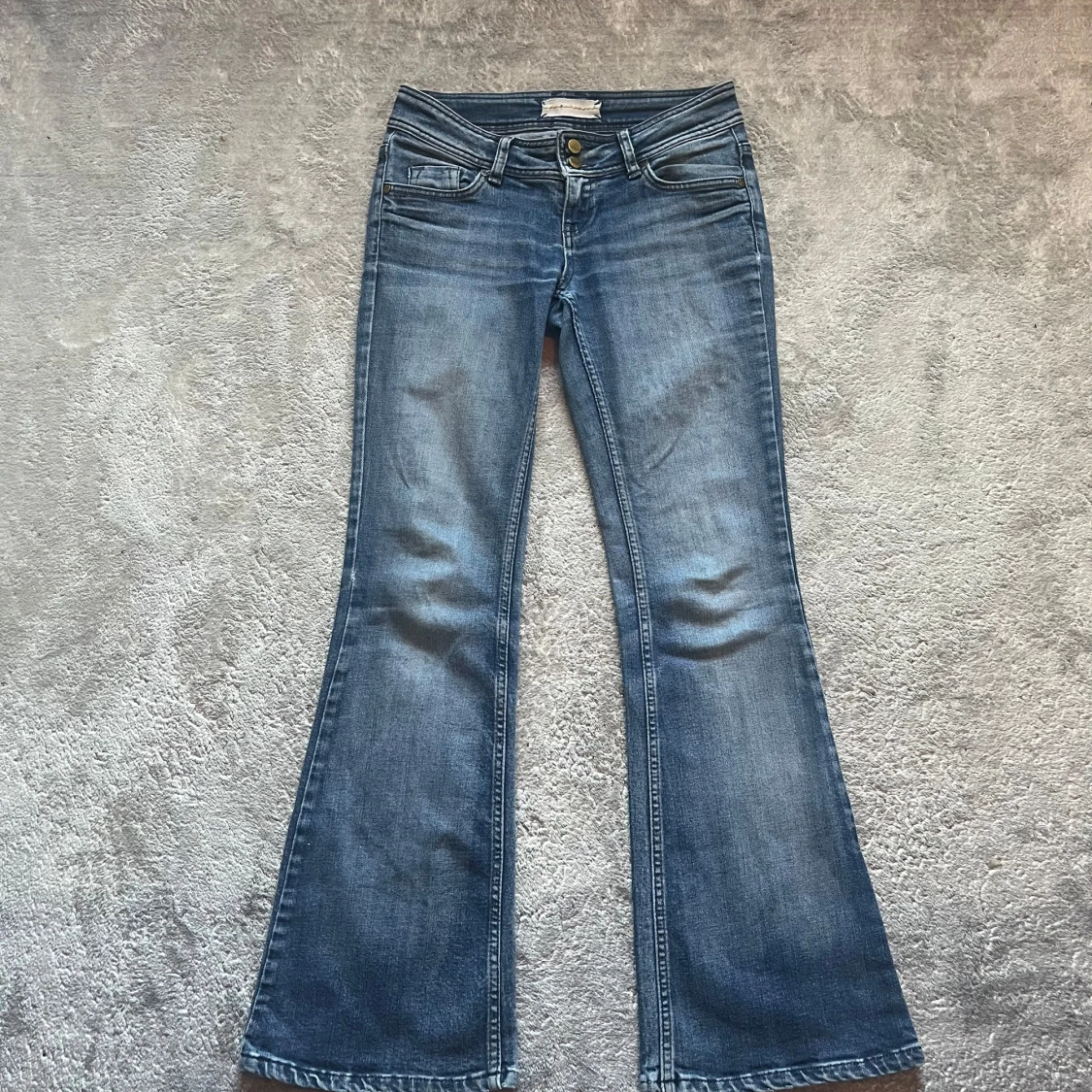 Blå bootcut jeans med broderade bakfickor