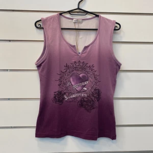 Bonita Topp 2000s Stones Y2k - En snygg linne med ett vackert tryck av ett hjärta med en krona och rosor. Linnet är i en vacker lila färg med en ombre-effekt. Massa diamanter finns även på trycket.  I bra skick med inga defekter  Storlek Medium   Skriv ifall du har några fler fråg