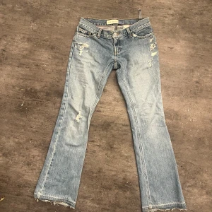 Lågmidjade blå jeans  - Superfina ultra lowwaist utsvängda jeans från gap. Midjemått: 38 cm Innerbenslängd:76 cm Jeansen har två rosa fläckar där bak och en ögla är sönder där bak 😊