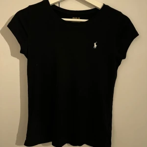 Svart ralph lauren t-shirt - Den är i nyskick och säljer den pga att jag aldrig använder den. Den är i storlek 12-14 och passar XS