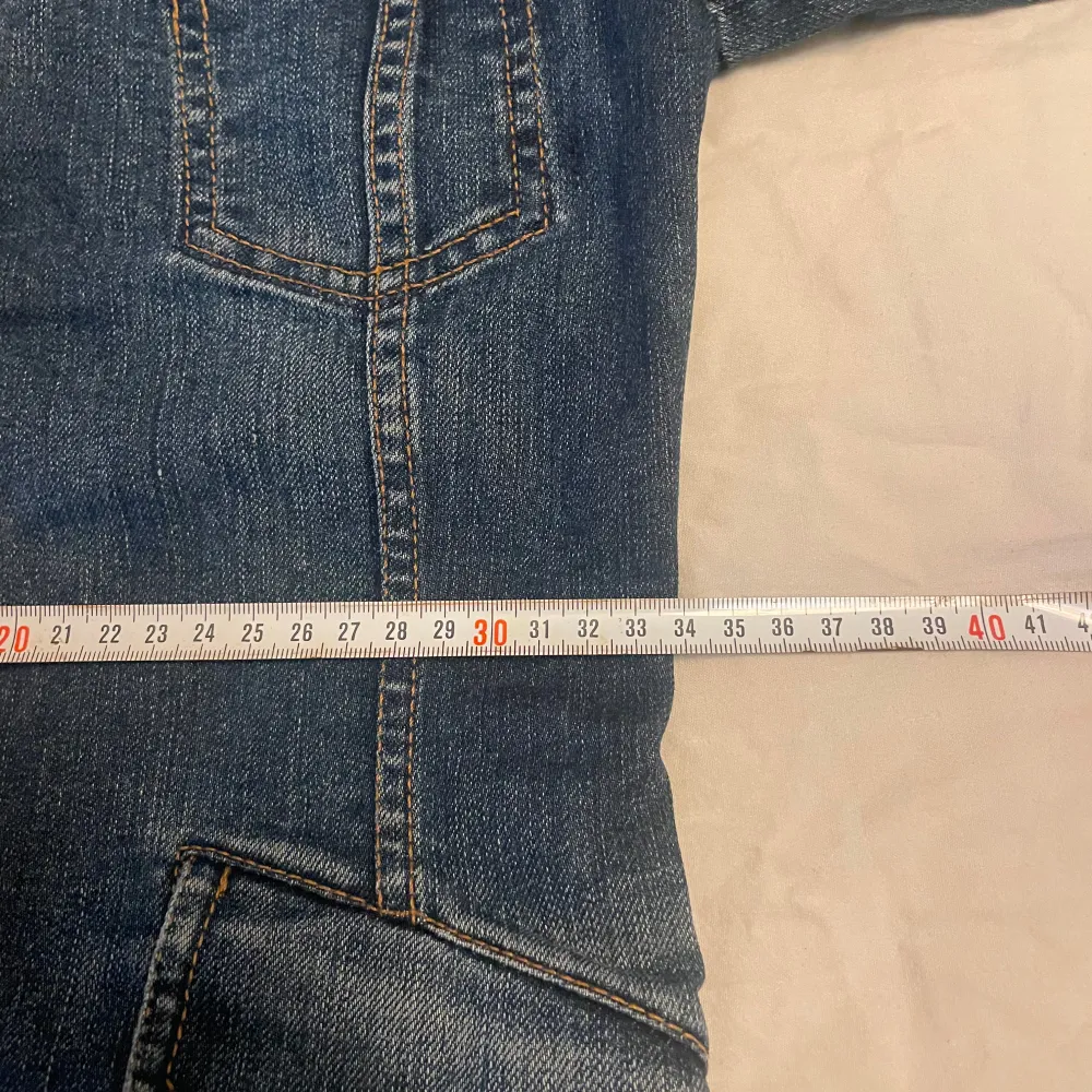 Säljer en snygg jeansjacka från D&G i klassisk blå denim. Jackan har en figursydd passform. Mått midja som bild 5, är 33 cm. Mått från armhåla till handled är 49 cm. Mått över byst 38cm. Står ingen storlek så XS är min gissning. . Takit.