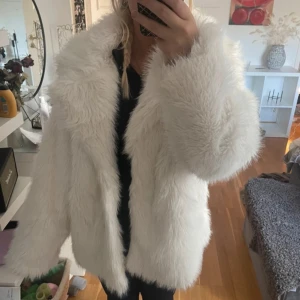 Vit pälsjacka från Nelly - Säljer en supermysig vit pälsjacka från Nelly. Perfekt för att hålla sig varm och snygg under kyliga dagar. Jackan har en fluffig och mjuk känsla med långa ärmar. Den är i mycket bra skick.✨