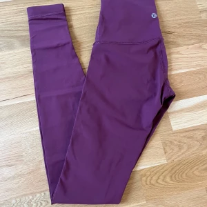 Mörklila tights från Lululemon - Jätte bekväma och snygga tights från Lululemon. Bra skick, säljer för att de är för små för mig. Storlek XS (USA 2). Oroignal priset 1 200.