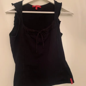 Svart topp - Snygg svart topp från Desigual. Den har en söt knytning framtill vid halsringningen och en enkel design som passar perfekt till både vardag och fest. 