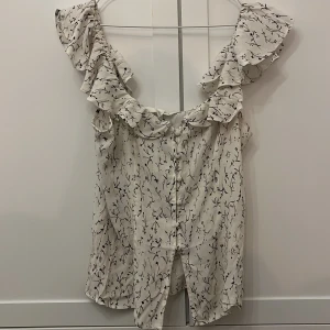 Vit blommig blus med volangdetaljer från hm! - Säljer en superfin vit blus från hm! Knappt använd så i bra skick, pris kan diskuteras.